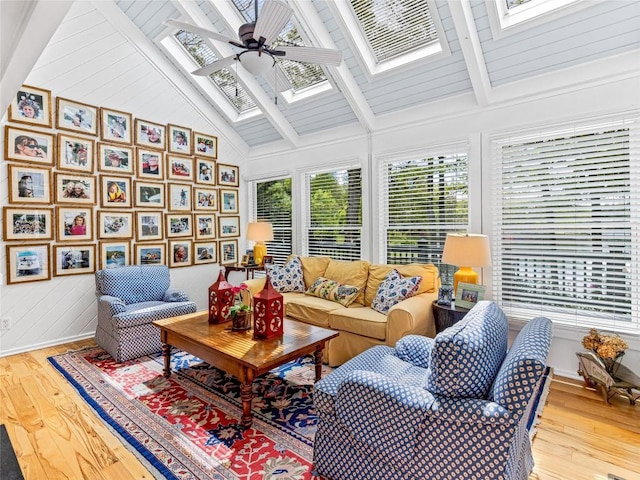 sunroom / solarium featuring a skylight, plenty of natural light, wood-type flooring, and wood walls