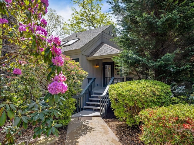 doorway to property with roof with shingles