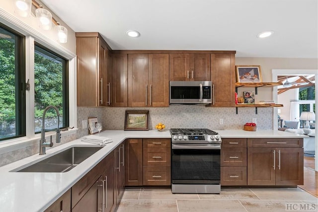 kitchen featuring backsplash, stainless steel appliances, sink, and a wealth of natural light