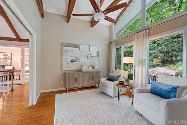 sitting room featuring hardwood / wood-style flooring, ceiling fan, radiator heating unit, high vaulted ceiling, and beamed ceiling