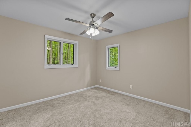 unfurnished room with light colored carpet and ceiling fan