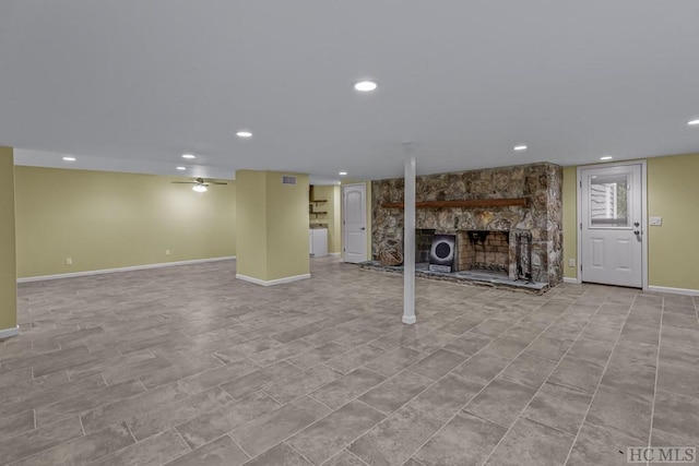 unfurnished living room with a stone fireplace and ceiling fan