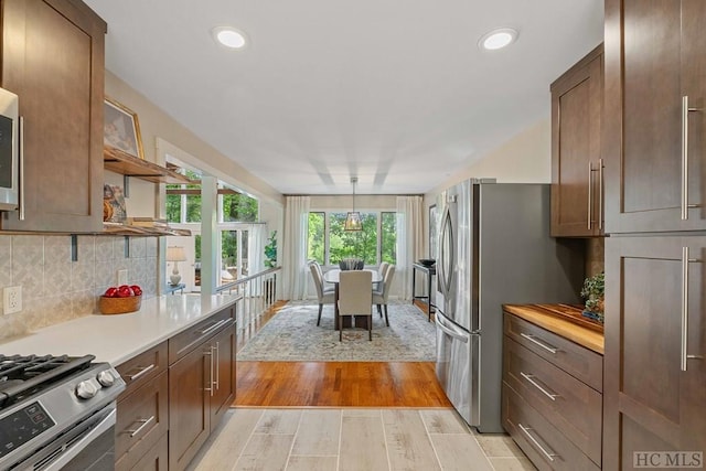 kitchen featuring tasteful backsplash, appliances with stainless steel finishes, and light wood-type flooring