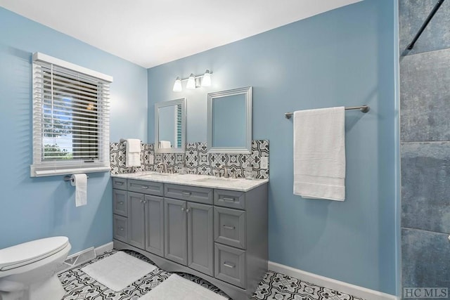 bathroom with vanity, toilet, tile patterned flooring, and decorative backsplash