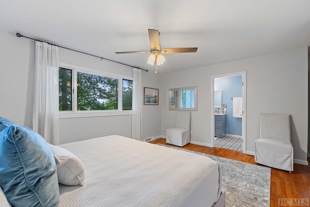 bedroom featuring ceiling fan, connected bathroom, and hardwood / wood-style floors