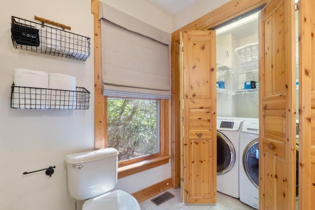 clothes washing area with visible vents, laundry area, and washer and dryer