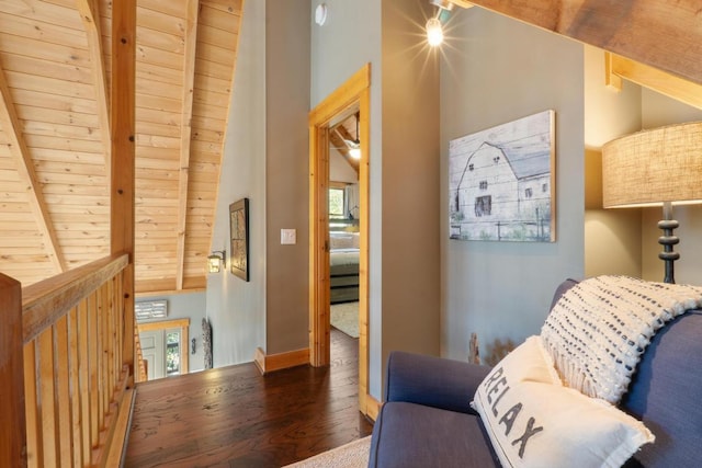 sitting room featuring baseboards, lofted ceiling with beams, wood finished floors, and wooden ceiling