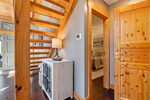 hallway with baseboards and dark wood-style floors