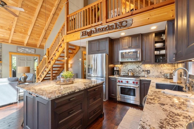 kitchen with dark wood-style flooring, appliances with stainless steel finishes, a sink, high vaulted ceiling, and tasteful backsplash