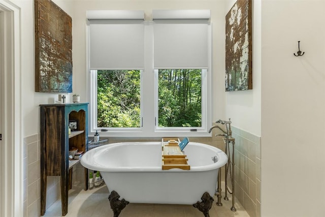 bathroom with a tub, tile patterned flooring, and tile walls