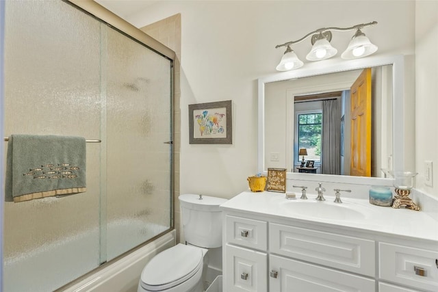 full bathroom featuring enclosed tub / shower combo, vanity, and toilet