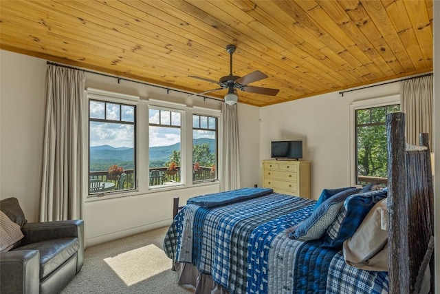 bedroom featuring light carpet, wooden ceiling, multiple windows, and ceiling fan