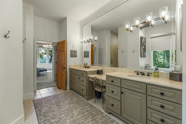 bathroom with vanity, a shower with shower door, a healthy amount of sunlight, and tile patterned floors