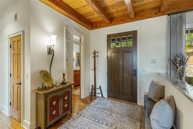 entryway featuring beam ceiling, light hardwood / wood-style flooring, and wooden ceiling