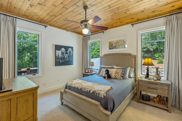 bedroom featuring ceiling fan, light colored carpet, multiple windows, and wood ceiling