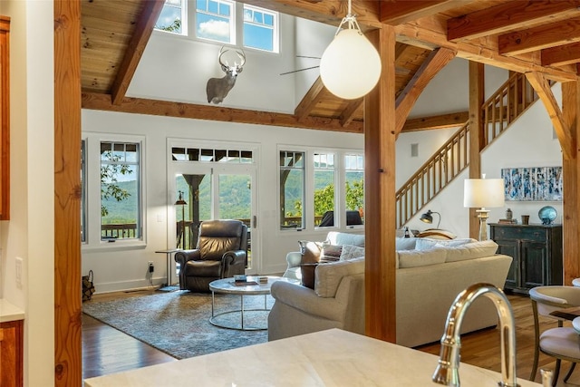 living room with hardwood / wood-style floors, beam ceiling, and high vaulted ceiling