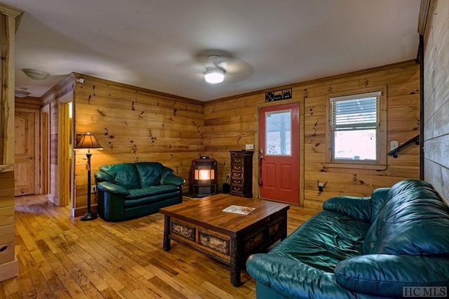 living room with hardwood / wood-style floors, ceiling fan, and wood walls