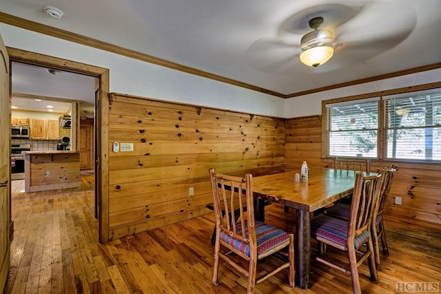 dining space featuring ceiling fan, crown molding, and light wood-type flooring