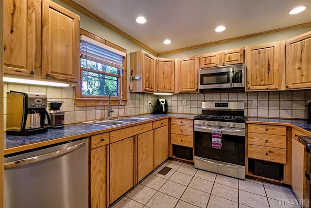 kitchen with light tile patterned flooring, sink, crown molding, appliances with stainless steel finishes, and decorative backsplash