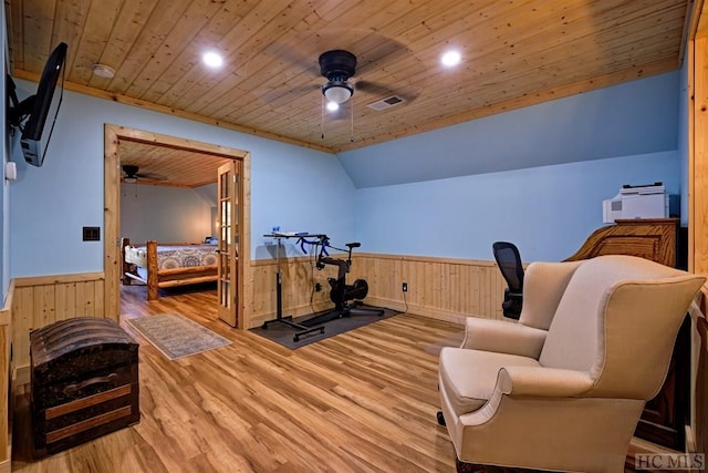 exercise area featuring wood-type flooring, wooden ceiling, ceiling fan, and wood walls