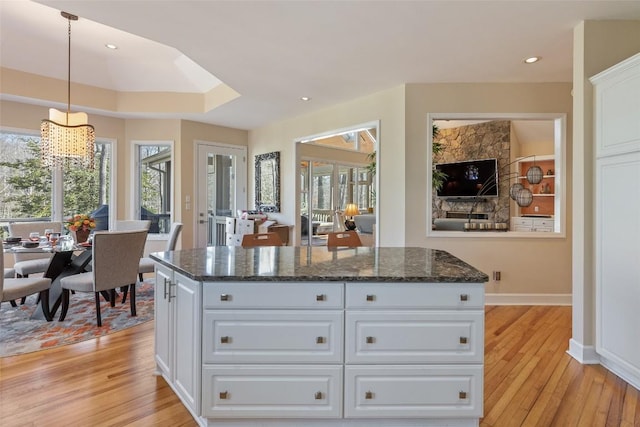 kitchen featuring light wood finished floors, plenty of natural light, and white cabinets