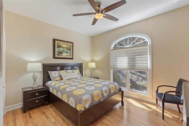 bedroom featuring a ceiling fan, baseboards, and wood finished floors