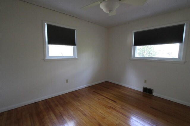 unfurnished room featuring visible vents, a ceiling fan, a wealth of natural light, and light wood-type flooring
