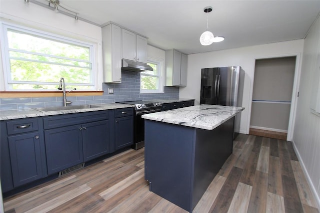 kitchen with visible vents, under cabinet range hood, tasteful backsplash, a sink, and stainless steel appliances