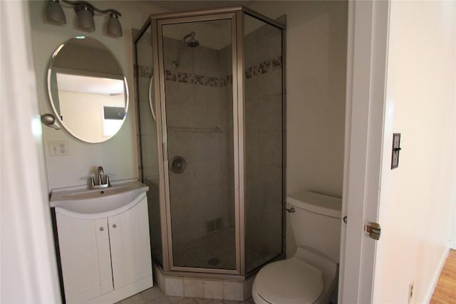 bathroom featuring vanity, toilet, and a shower stall