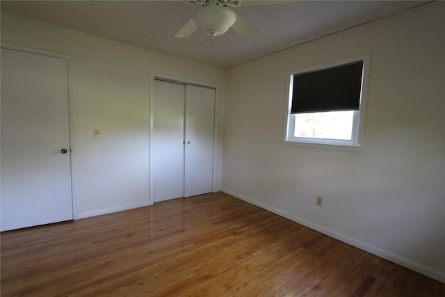 unfurnished bedroom with a closet, baseboards, a ceiling fan, and light wood-style floors