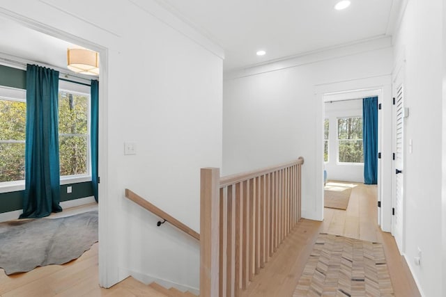 corridor with recessed lighting, an upstairs landing, light wood-style floors, and ornamental molding