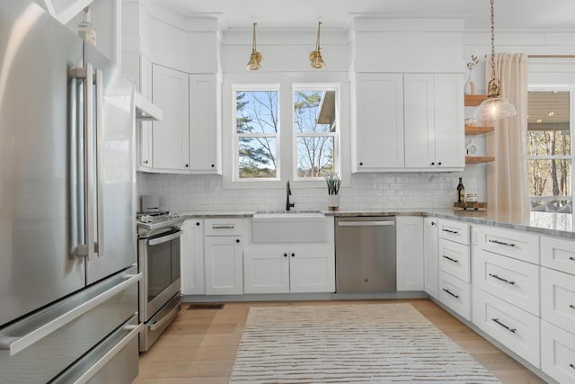 kitchen with open shelves, a sink, stainless steel appliances, white cabinetry, and tasteful backsplash