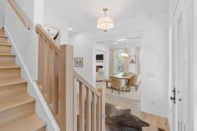 stairs featuring a chandelier, recessed lighting, baseboards, and wood finished floors