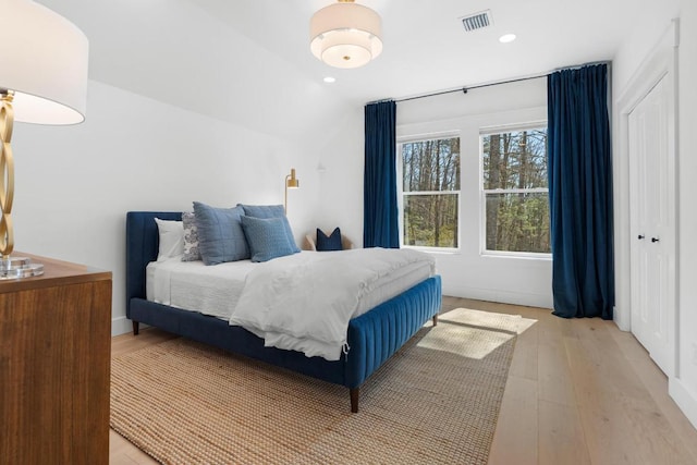 bedroom featuring recessed lighting, light wood-type flooring, visible vents, and a closet