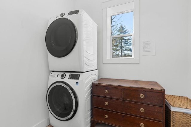 clothes washing area featuring laundry area and stacked washing maching and dryer