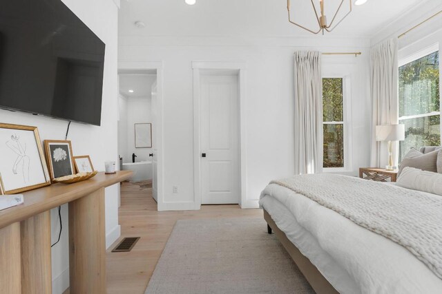 bedroom featuring recessed lighting, visible vents, ornamental molding, and light wood finished floors