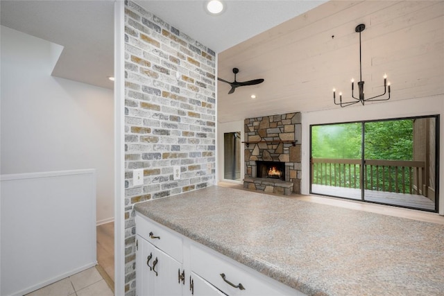 233 Meadow Way Unit 1615, Sapphire, NC 28774 - kitchen featuring white cabinetry, light tile patterned flooring, a chandelier, a stone fireplace, and light countertops