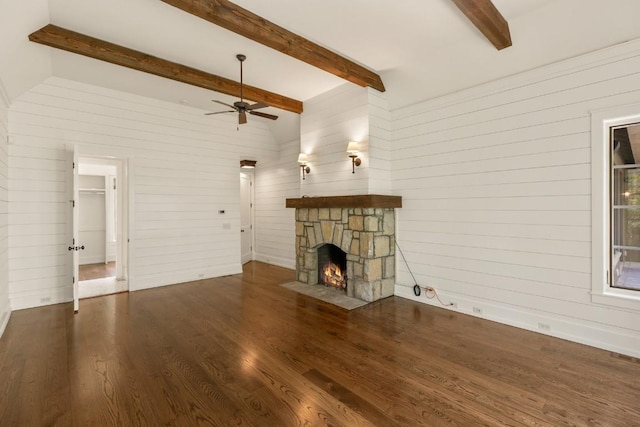 525 High Mountain Dr, Cashiers, NC 28717 - unfurnished living room featuring wooden walls, wood finished floors, a stone fireplace, a ceiling fan, and beamed ceiling