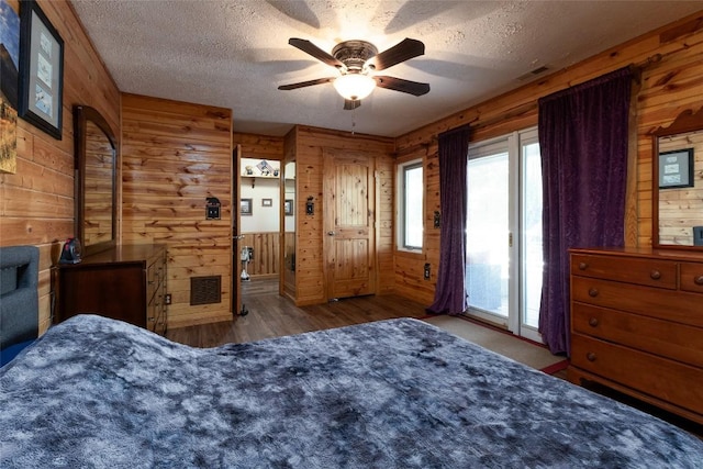 3050 N Hwy 107, Cashiers, NC 28736 - bedroom featuring wooden walls, access to outside, a textured ceiling, wood finished floors, and a ceiling fan