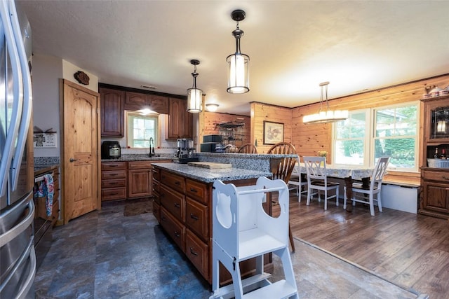 3050 N Hwy 107, Cashiers, NC 28736 - kitchen featuring stainless steel fridge, decorative light fixtures, a center island, brown cabinets, and dark stone counters