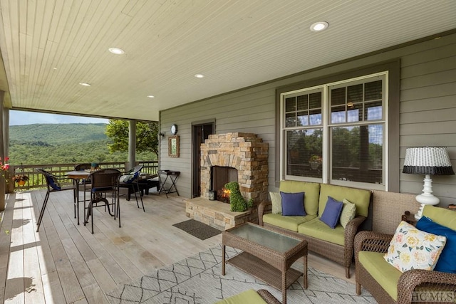 wooden deck with an outdoor living space with a fireplace