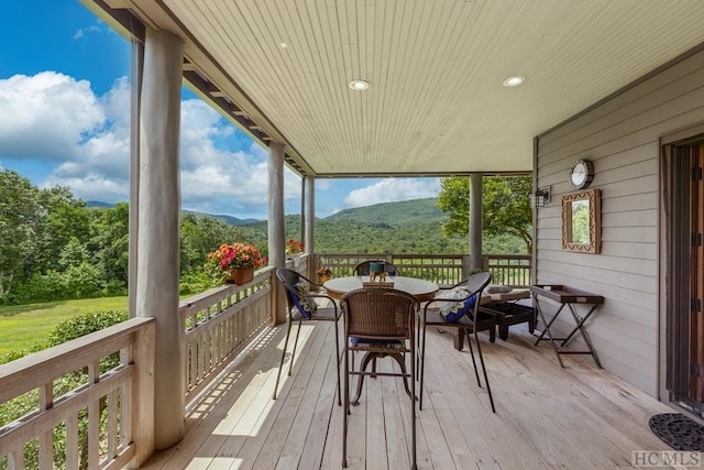 sunroom featuring a mountain view and wooden ceiling