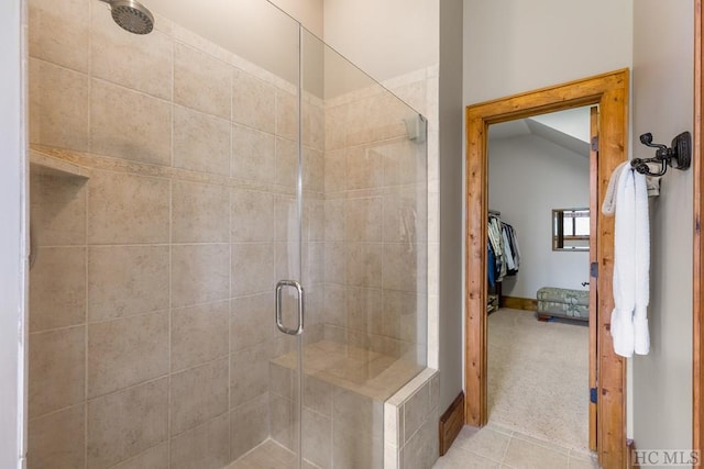 bathroom with a shower with shower door and vaulted ceiling