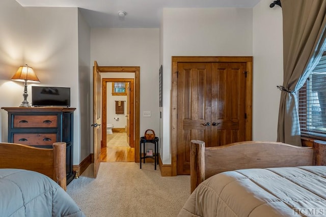 bedroom featuring a closet and light colored carpet