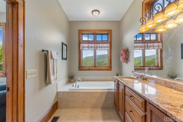 bathroom with tiled bath, tile patterned floors, and vanity