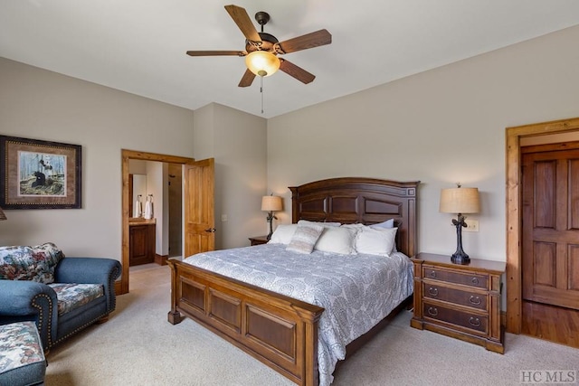 bedroom featuring connected bathroom, light carpet, and ceiling fan