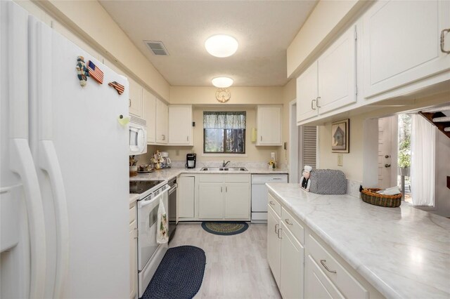 kitchen with visible vents, white appliances, light countertops, and white cabinetry