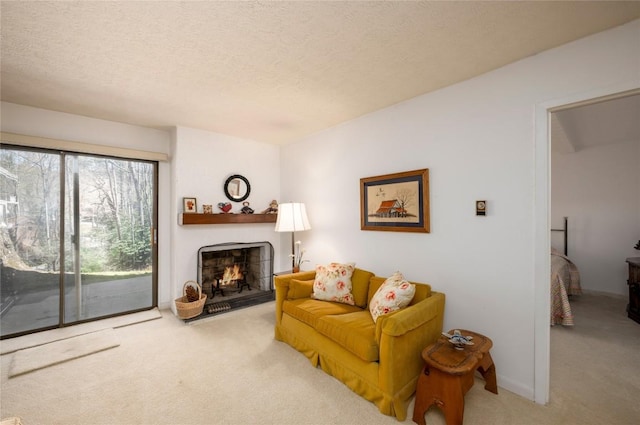 carpeted living area with a textured ceiling and a lit fireplace