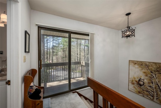 doorway to outside with an inviting chandelier