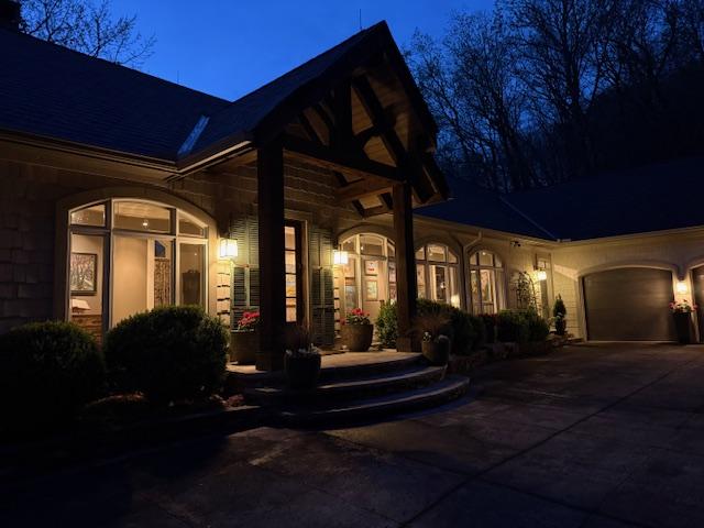 170 Old Hunters Run, Cashiers, NC 28717 - exterior entry at twilight featuring concrete driveway and an attached garage